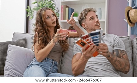 A woman and man discuss home decorating ideas in their living room, with color swatches and coffee in hand.