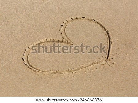 Heart drawn in the sand. Shallow depth of field.