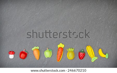 recreation of pieces of fruit and vegetables in slate background