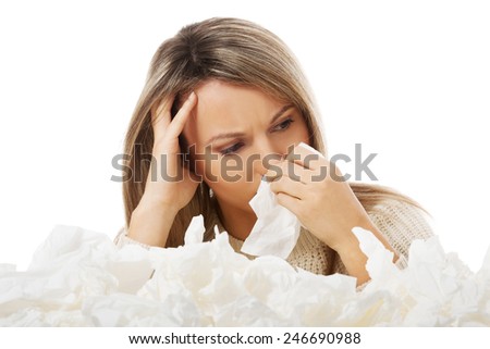 Young woman in lot of tissues around, ill