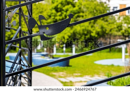 figure of a dog's head on the fence. dog head symbol. entrance to the dog walking area. metal dog figure
