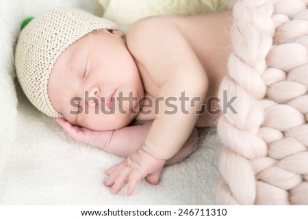 Newborn baby sleeping with colored hat