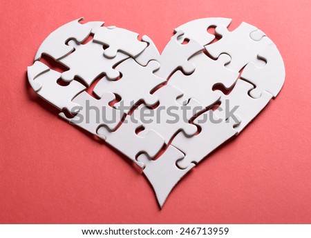 Broken Heart Made Of White Jigsaw Puzzle Over Orange Background