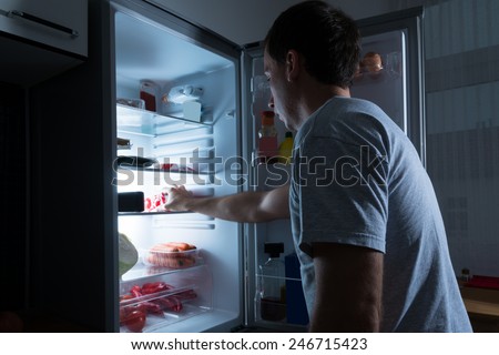 Portrait Of A Man Taking Food From Refrigerator Royalty-Free Stock Photo #246715423