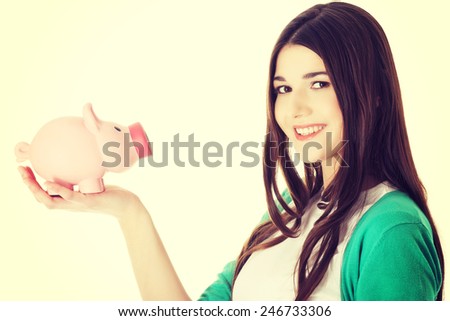 Young casual woman holding piggy-bank.