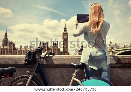 Girl with a tablet against UK Parliament