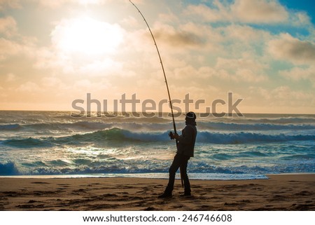 Man fishing on Beach at Sunset Royalty-Free Stock Photo #246746608
