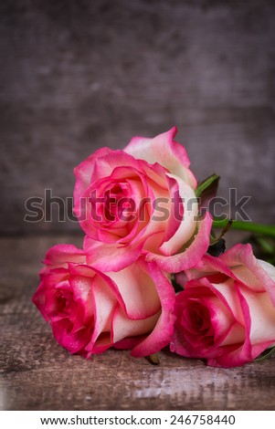 Background with fresh flowers. Roses on wooden table. Selective focus.