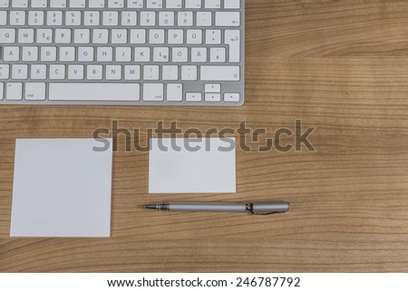 Modern keyboard a memo and a pen of coffee on a wooden Desktop
