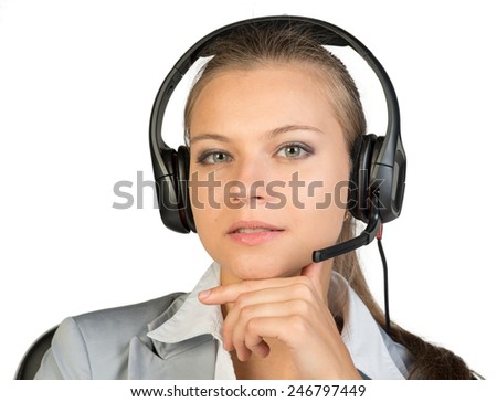 Businesswoman in headset sitting on chair, hand under chin, lips parted, looking at camera. Isolated over white background