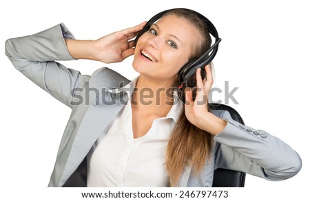 Businesswoman in headset with her hands on speakers, her had tilted back and sideways, looking at camera, laughing. Isolated over white background
