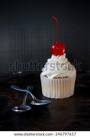 vanilla sweet cupcake with italian butter cream put on grunge tray with spoon , image dark tone