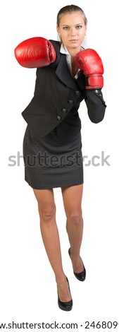 Businesswoman wearing boxing gloves punching towards camera. Isolated over white background