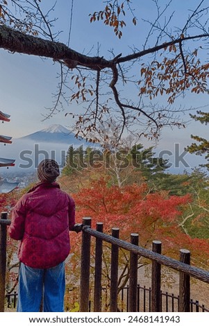 One Young Japanese Female Taking Pictures of Mt. Fuji Viewed From Behind Chureito Pagoda in Japan. Vertical Image