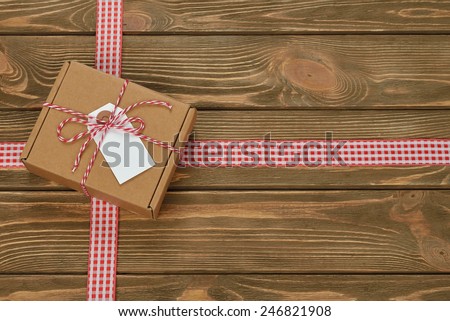 Box decorated with ribbon on a brown background