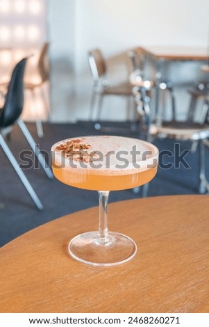 Glass of Cold Orange Mocktail on table,female hand swirling red wine in wine glass,Friends cheering with wineglasses.