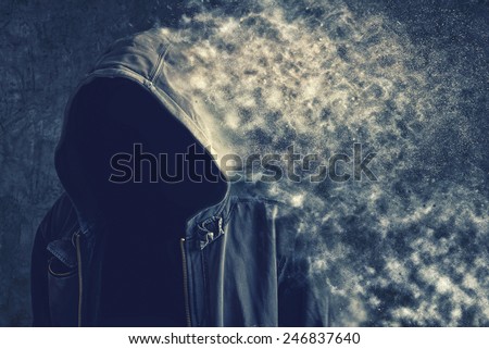 Faceless unknown and unrecognizable man without identity disintegrating and vanishing into the dust particles, life dissolving concept.