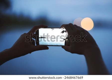 Sunset, picture and hands of person with phone, screen and social media post of nature, landscape or lake. Mobile, photography or technology for memory of outdoor vacation, holiday and night view