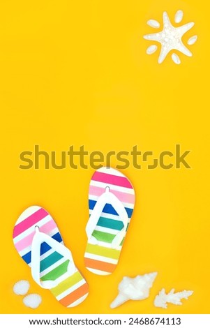 Summer holiday travel concept with rainbow flip flops, decorative seashells, abstract starfish sun on yellow background. Vacation fun with LGBT theme.