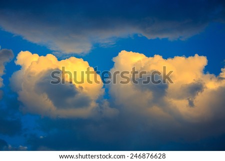 Two golden sunset clouds on a blue sky