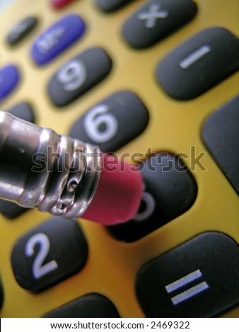 Closeup of a pencil pushing buttons on a calculator