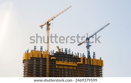 High-rise Building Under Construction Against the Blue Sky. Construction Cranes. Architecture and city development. High quality photo