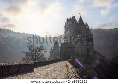 View of Eltz Castle. An autumn landscape on a frosty morning with frost and fog. The Known Castle is in a valley and forest dating from the 12th century in Wierschem, Rhineland Palatinate Germany