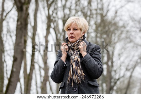 Depressed or sad woman walking down a barren path in winter Royalty-Free Stock Photo #246972286