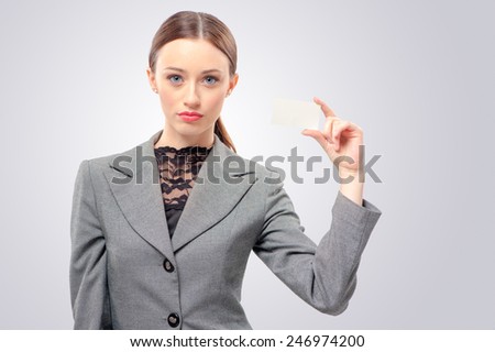 Lady with business card. Confident young woman holding business card in her hand and while standing isolated on white