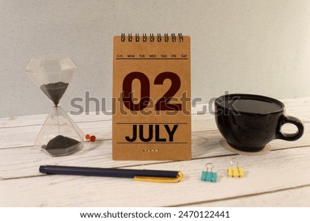 Close up of a wooden perpetual calendar showing the 2nd of July. Shot close up isolated on a white background.