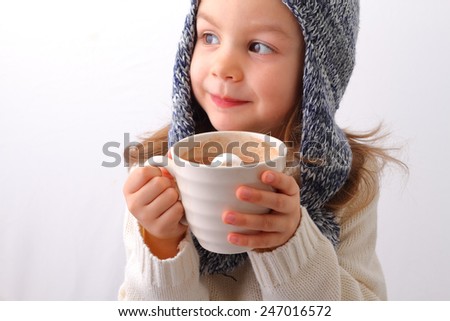 A cute little girl drinking hot chocolate with marshmallow
