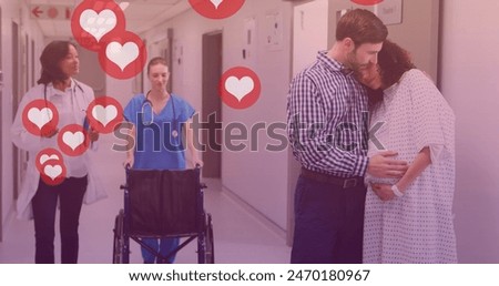 Image of heart icons over caucasian man embracing pregnant wife in hospital. maternal mental health awareness week concept digitally generated image.