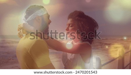 Image of spots over diverse couple embracing. Free time and digital interface concept digitally generated image.