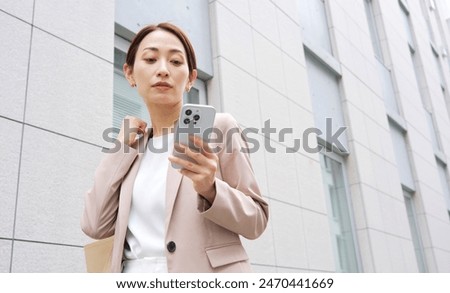 Asian businesswoman using the smartphone outdoor