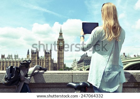 Girl with a tablet against UK Parliament