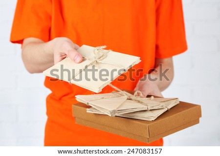 Courier with parcel box and letters close-up