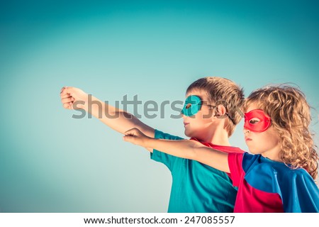 Superhero children against summer sky background. Kids having fun outdoors. Boy and girl playing. Success and winner concept Royalty-Free Stock Photo #247085557