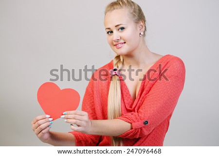young beautiful blonde woman holding a heart
