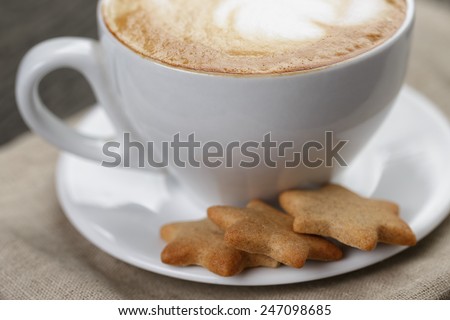 cup of cappuccino with home cookies, on old table
