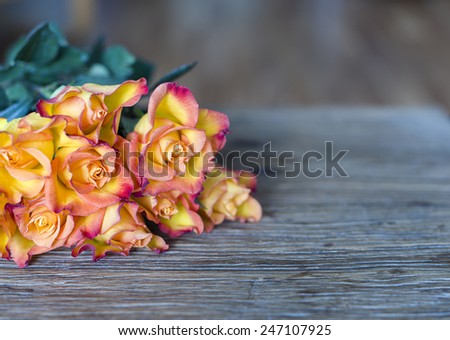 bunch of orange roses on wooden background