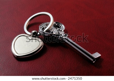 Metaphoric "key to heart" lying on red textural background