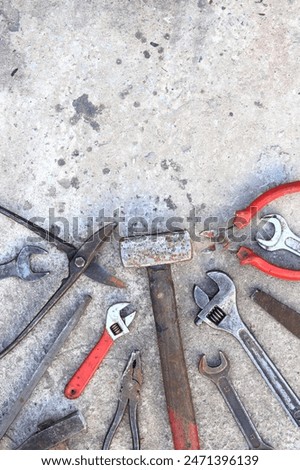 Old working tools on a concrete surface, top view. Hammers, flat file, tin snips, adjustable wrench and wrench. Hand tool. Builder's Day or Father's Day. Construction and renovation concept