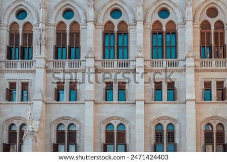 A close-up view of a historic building facade in Budapest, Hungary, showcasing its detailed stonework and arched windows. Perfect for travel and architecture photography.