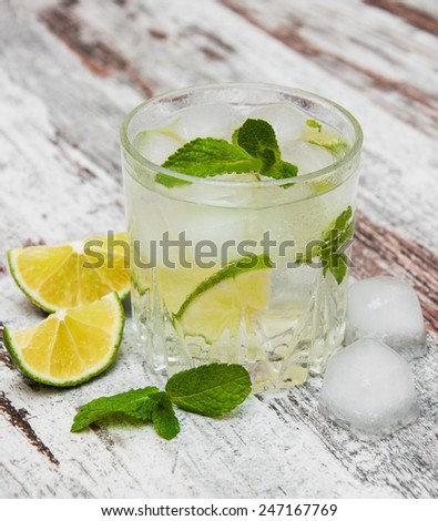 Cold fresh lemonade drink on a wooden background