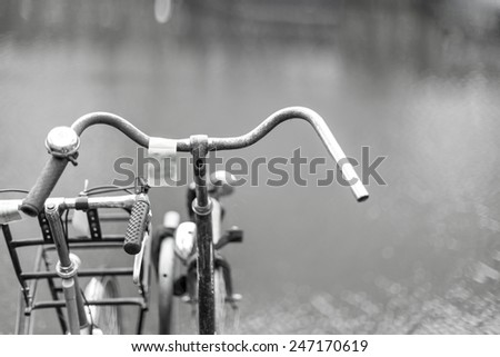 Artistic image of two bicycles near a river.