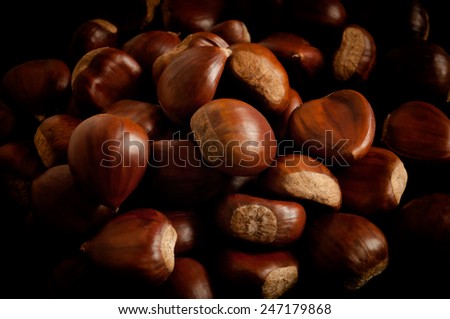Group of chestnuts illuminated by a light side. Dark background
