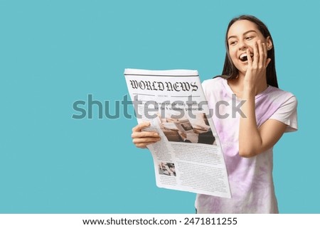 Beautiful young woman with newspaper on blue background
