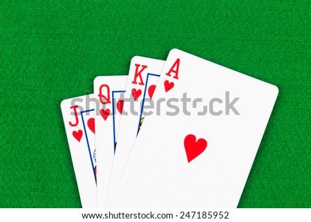 Royal flush poker playing cards on green felt background