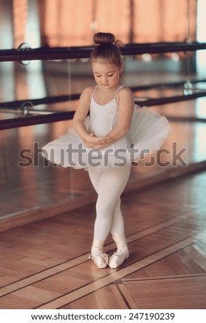 in the hall near the large mirrors dancing little ballerina in white tutu