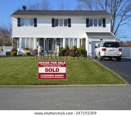 Real estate sold (another success let us help you buy sell your next home) sign White Suburban High Ranch home clear blue sky autumn day residential neighborhood USA